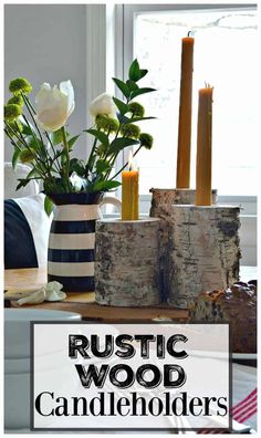 rustic wood candle holders with flowers and candles in them on a table next to a window