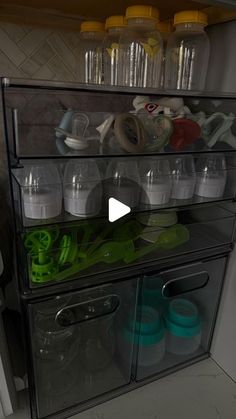 an image of a kitchen cabinet filled with dishes and cups on it's shelves