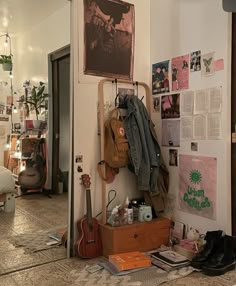 a room filled with lots of clutter next to a wall covered in posters and pictures