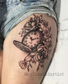 a woman's thigh with a clock and flowers on it