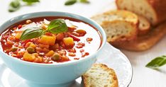 a bowl of soup with bread on the side