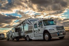 an rv is parked on the side of the road under a cloudy sky with clouds