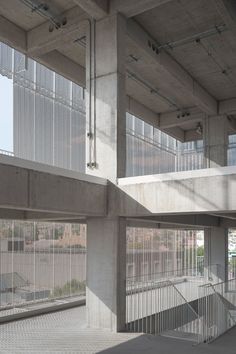 an empty parking garage with lots of windows and railings on the side of it