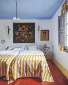 a bed sitting under a painting on the wall