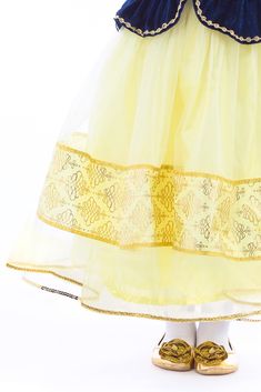 This finely detailed Deluxe Snow White dress will make your little one feel like dwarves are going to come join them on an adventure at any moment. Soft stretch navy velvet bodice and matching peplums that are adorned with golden embroidery Yellow china silk skirt overlain with an organza overskirt with a band of golden decorations Classic striped puff sleeves and white ruffle neck complete the look Breathable, Silky Soft, 100% Polyester Fabrics Accessories Sold Separately **Size Small Does Not Festive Princess Dress In Gold, Festive Princess Gold Dress, Festive Gold Princess Dress, Festive Princess Dress, Gold Dress For Festive Costume Party, Organza Overskirt, Snow White Dress, Ornate Necklace, Snow White Dresses