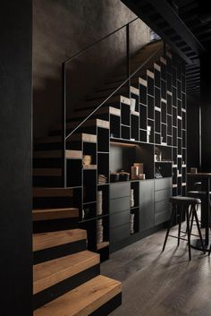 an empty room with black walls and wooden steps leading up to the second floor area