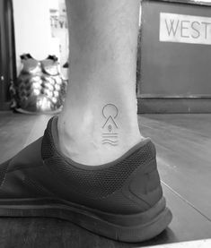 a man's foot with a small tattoo on the side of his ankle that reads,