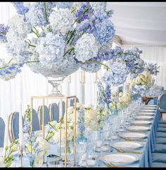 a long table is set with blue and white flowers