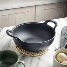 an iron skillet sitting on top of a counter next to eggs