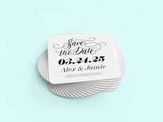 save the date coasters on top of each other in front of a blue background