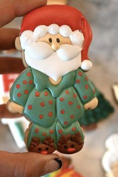 a hand holding a christmas ornament with a santa clause on it