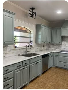 a kitchen with gray cabinets and marble counter tops