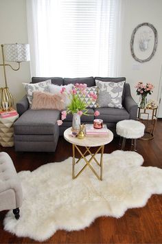 a living room filled with lots of furniture and flowers on top of a white rug