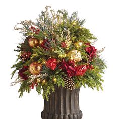 a vase filled with christmas decorations and greenery