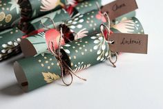 several rolls of green wrapping paper tied together with twine and brown tags on them