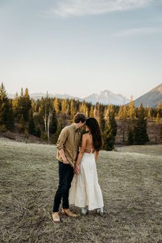 a man and woman standing next to each other in a field