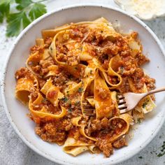 a white bowl filled with pasta and meat sauce