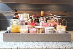 a tray filled with lots of different types of candy canes and coffee mugs