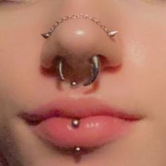 a woman with piercings on her nose and nose ring in front of her face