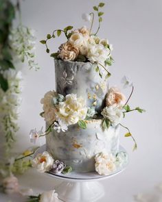 three tiered cake decorated with flowers and greenery