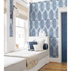 a bedroom with blue and white wallpaper in the corner, along with a day bed