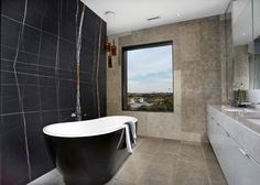 a bathroom with a large bathtub next to a window