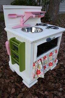 an old fashioned toy stove with sink and oven in the middle of leaves on the ground