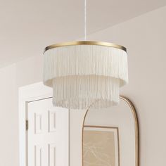 a white chandelier hanging from the ceiling in a room with a mirror and door