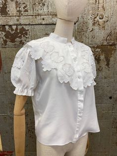 "Homemade Vintage Blouse. It's hard to date this shirt as I think it's been made from re-purposed fabric.  It has short, puff sleeves and a lovely decorative yoke with cutwork & embroidery details.  Please see the measurements below and compare with an item that you already own:  Bust 38\" Underarm to underarm 19\"  Nape of neck to hem 22\" Shoulder to Shoulder 16\" Excellent vintage condition. If you have any questions or require any additional photos, please don't hesitate to contact me. All i Fitted Broderie Anglaise Short Sleeve Top, Fitted Short Sleeve Top With Broderie Anglaise, Cotton Puff Sleeve Top With Floral Embroidery, White Puff Sleeve Top With Floral Embroidery, Cotton Embroidered Puff Sleeve Blouse, Fitted Embroidered Tops With Puff Sleeves, Fitted Blouse With Peter Pan Collar And Embroidery, Fitted Embroidered Blouse With Peter Pan Collar, Cotton Puff Sleeve Top With Lace Collar