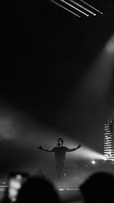 a man standing on top of a stage with his arms outstretched