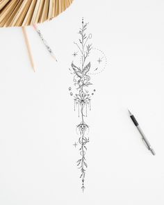 a pencil drawing of a flower on paper next to some scissors and a pen,