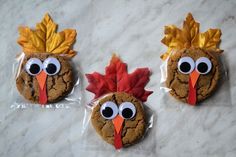 three cookies decorated to look like turkeys with googly eyes and leaves on them