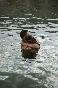 two people in the water hugging each other