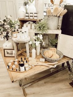 an assortment of products displayed on a table in a room with white walls and wooden floors