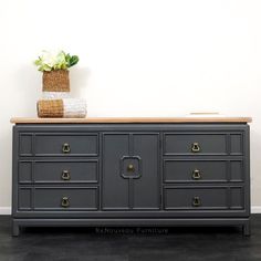 a grey dresser with gold handles and drawers