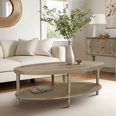 a living room filled with furniture and a plant in a vase on top of a coffee table