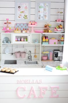 there is a small kitchen with pink and white decor on the wall above the sink