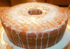 a bundt cake sitting on top of a white plate covered in icing and drizzle