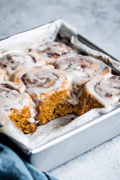 a pan filled with cinnamon rolls covered in icing