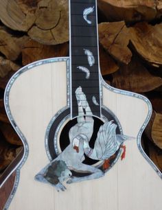 a wooden guitar with an image of a bird on it's back and neck