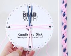 a hand holding a white clock with pink string attached to it