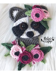 a crocheted raccoon with flowers on it