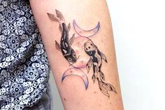 a woman with a tattoo on her arm has a koi fish and crescent moon