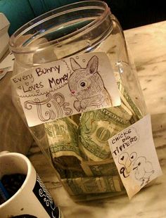 a jar filled with money sitting on top of a table