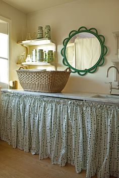 a basket sitting on top of a counter next to a sink under a mirror in a kitchen