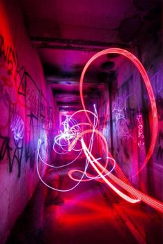 a long exposure photo of light painting in an alleyway with graffiti on the walls