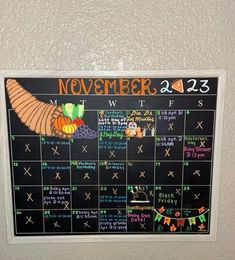 a chalk board with the calendar for november and december written in orange, green, and blue