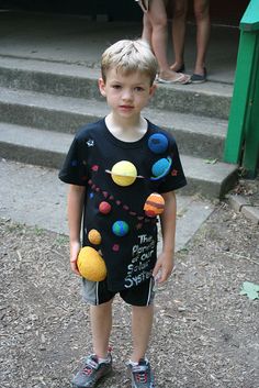 a young boy standing in front of some steps with his hand on the ball that he is holding