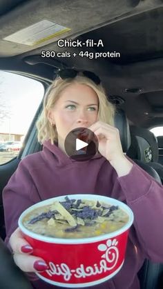 a woman sitting in the back seat of a car holding a bowl of food