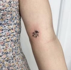 a ladybug tattoo on the left arm